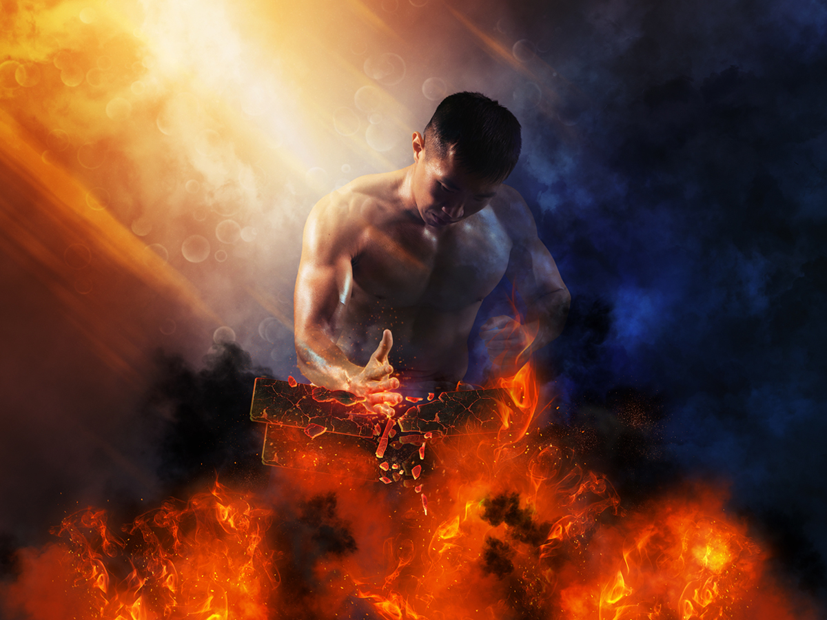 Mann zerschlägt brennende Backsteine mit seiner Hand